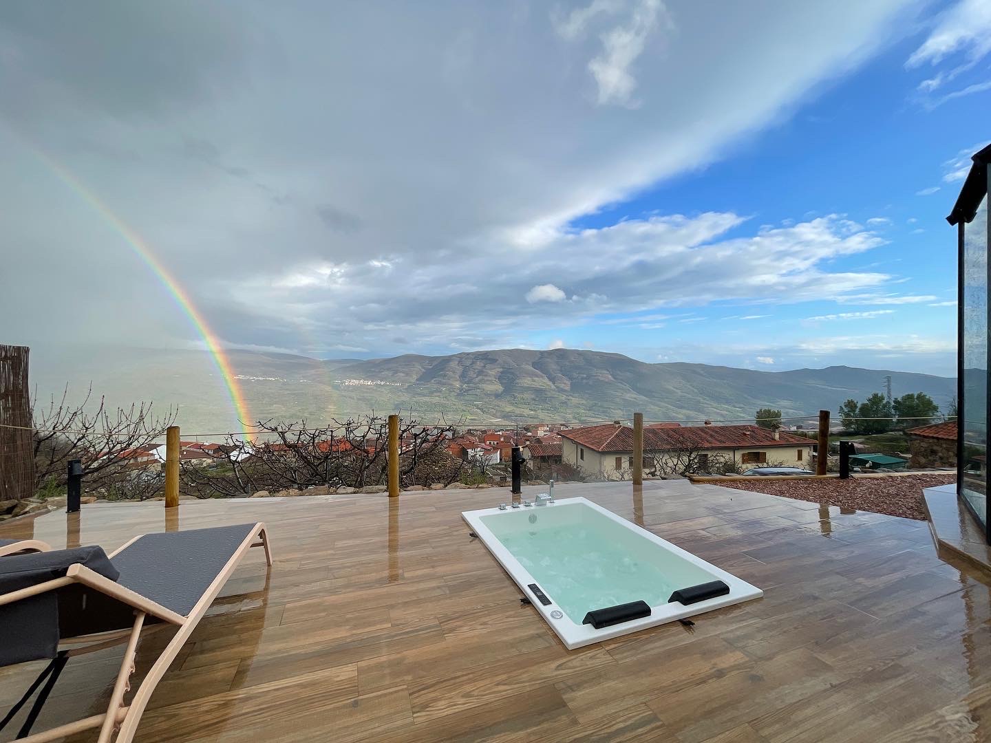 Vista exterior de una tienda glamping con chimenea, rodeada de pinos