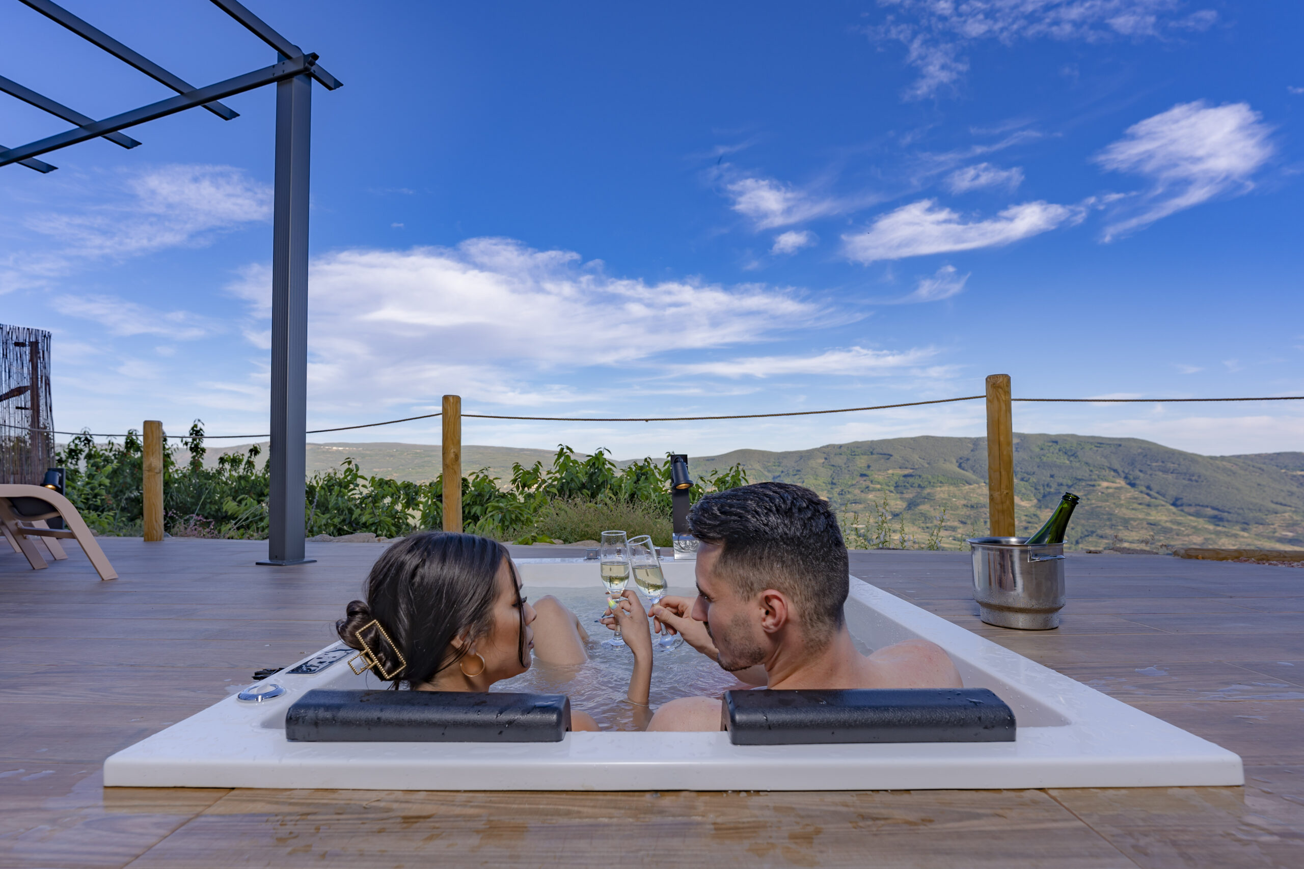Cabaña glamping iluminada al atardecer con jacuzzi privado